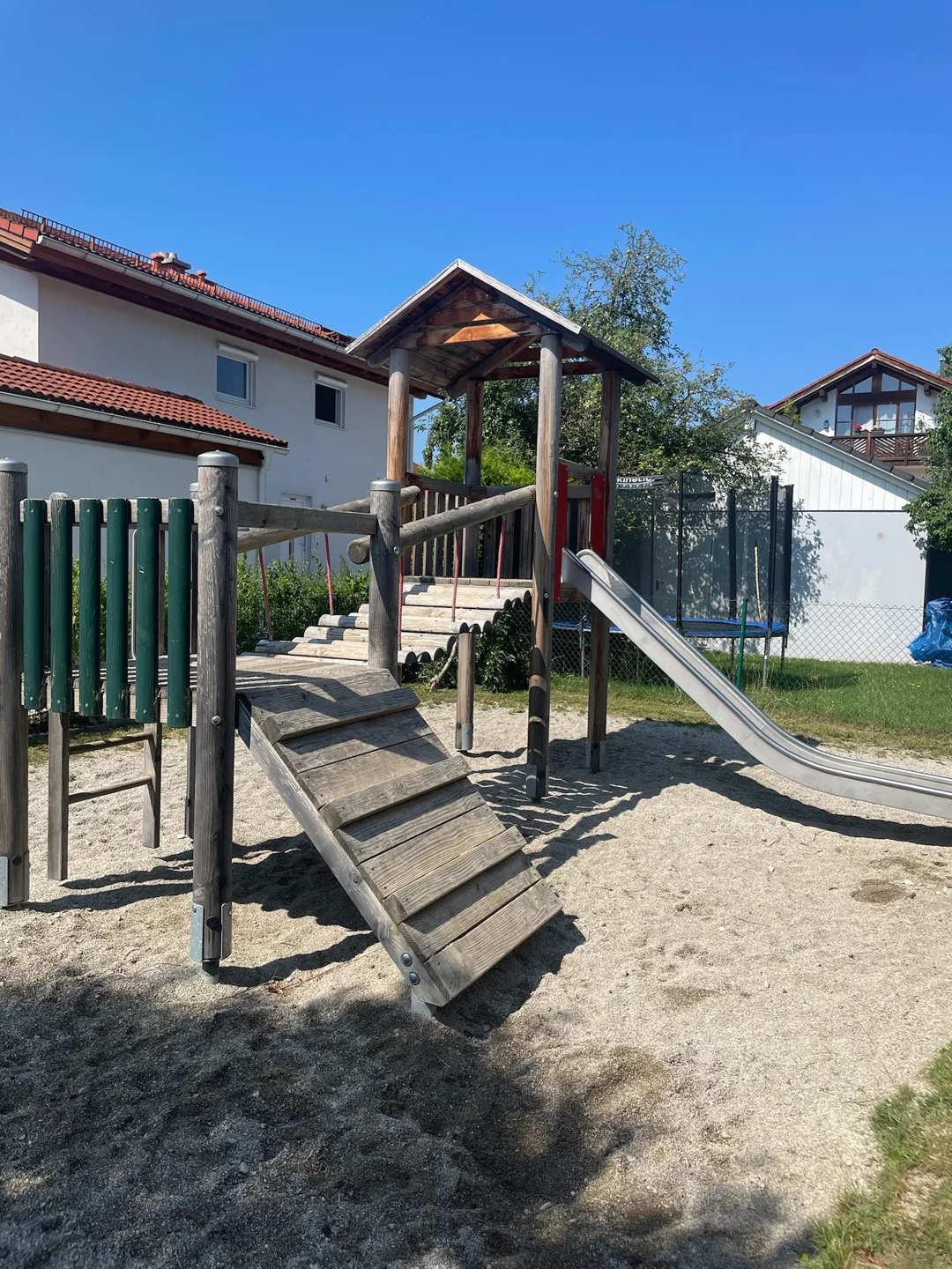 Spielhaus, Holzbrücke und Rutsche im Garten der Großtagespflege Fuchsbau