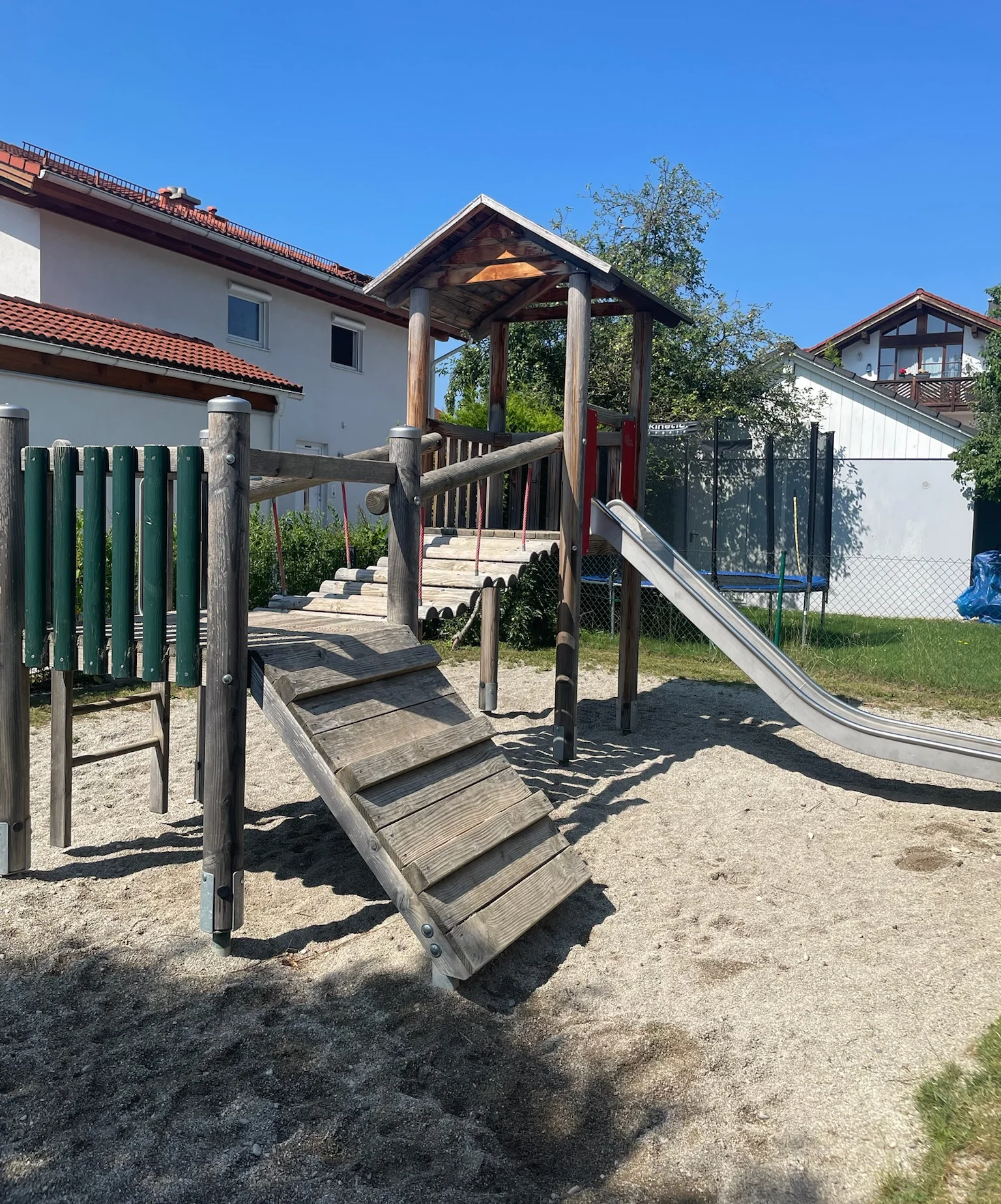 Kletterturm mit Holzbrücke und Rutsche im Garten