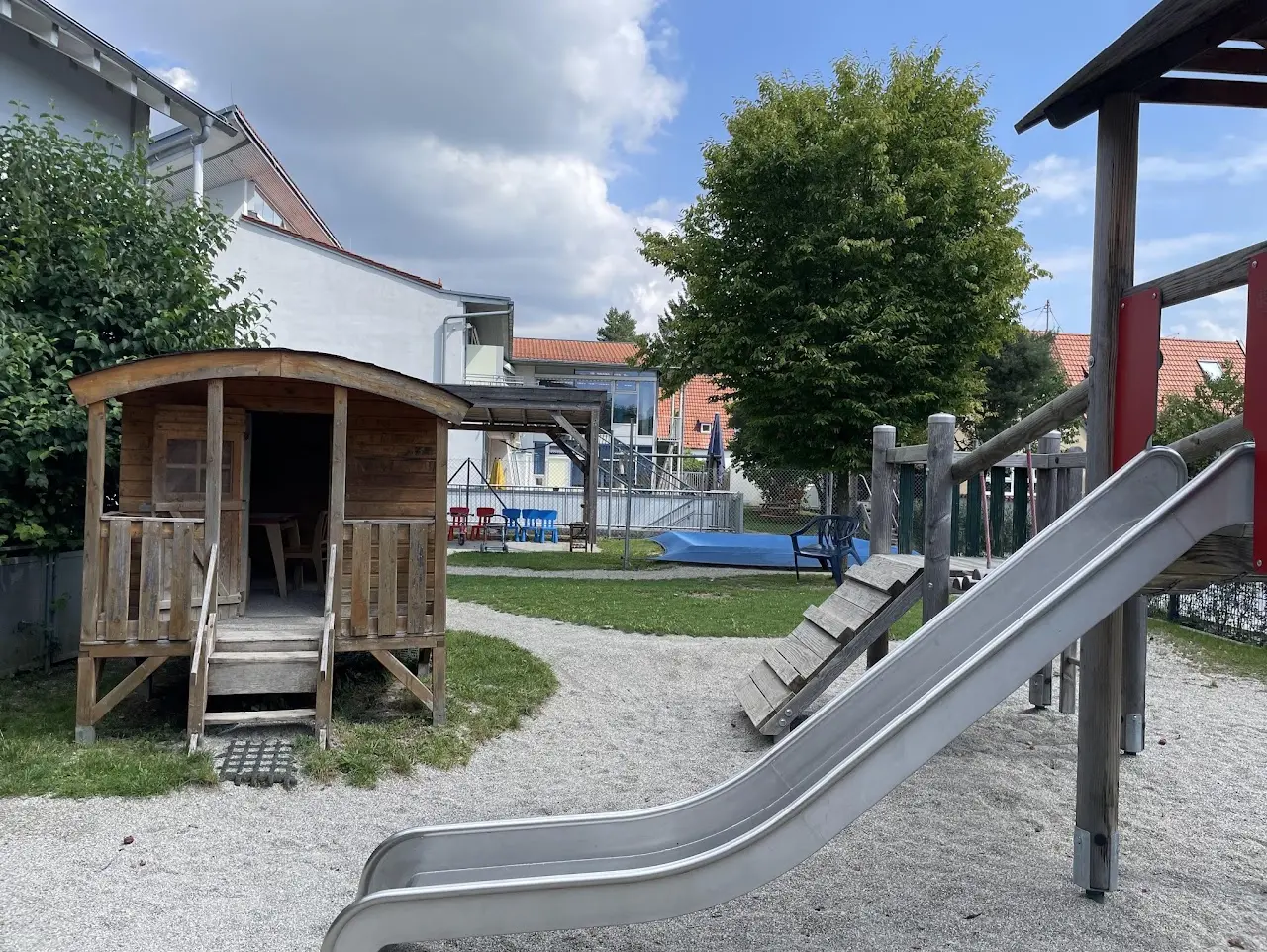 Garten der Großtagespflege mit Spielhaus und Rutsche